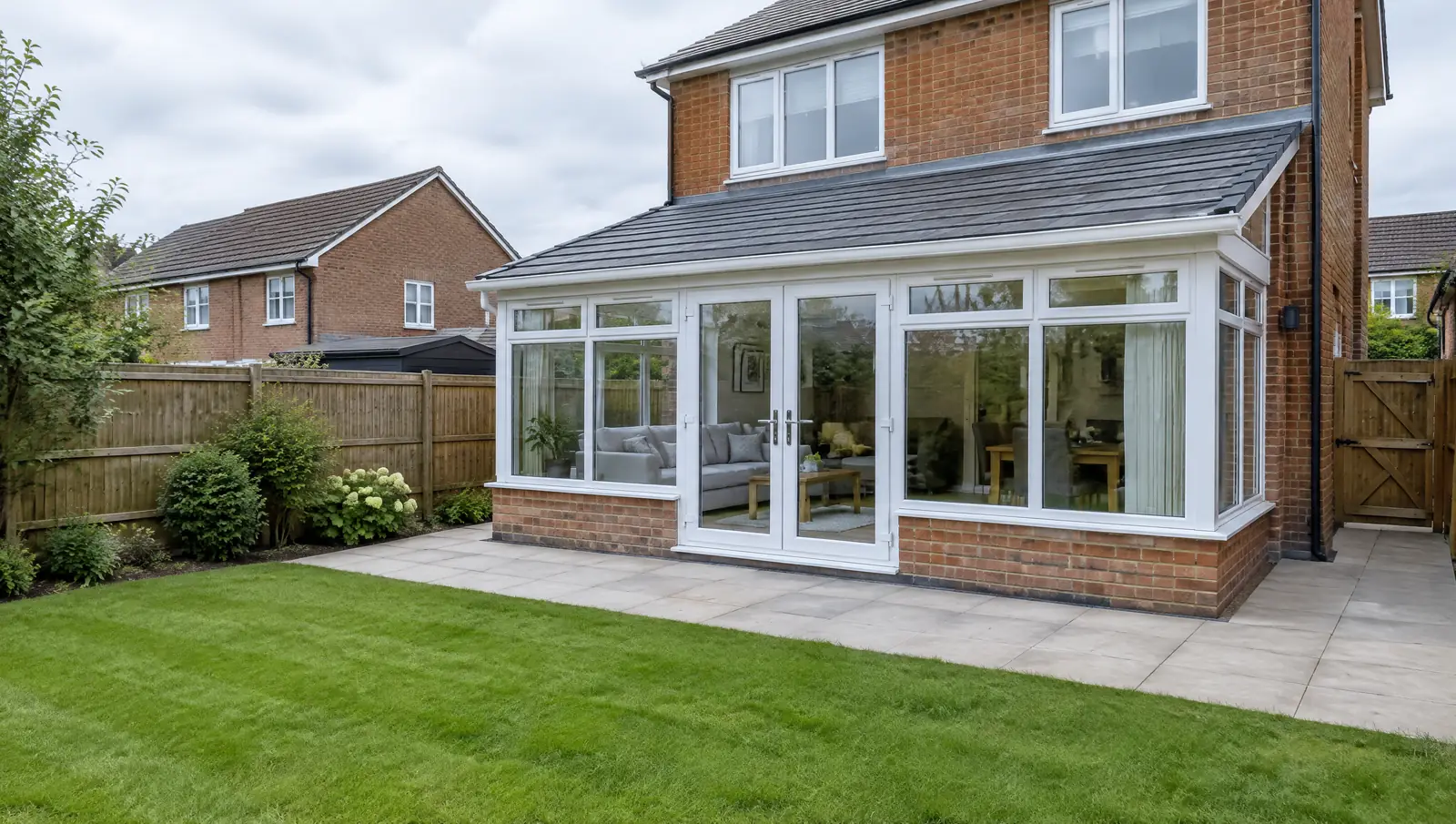 Modern lean-to conservatory with a solid tiled roof on the back of a British brick house