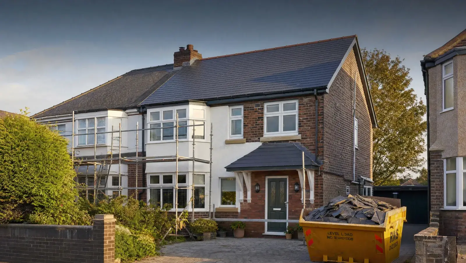 Newly completed slate roof on a UK semi-detached house with scaffolding coming down