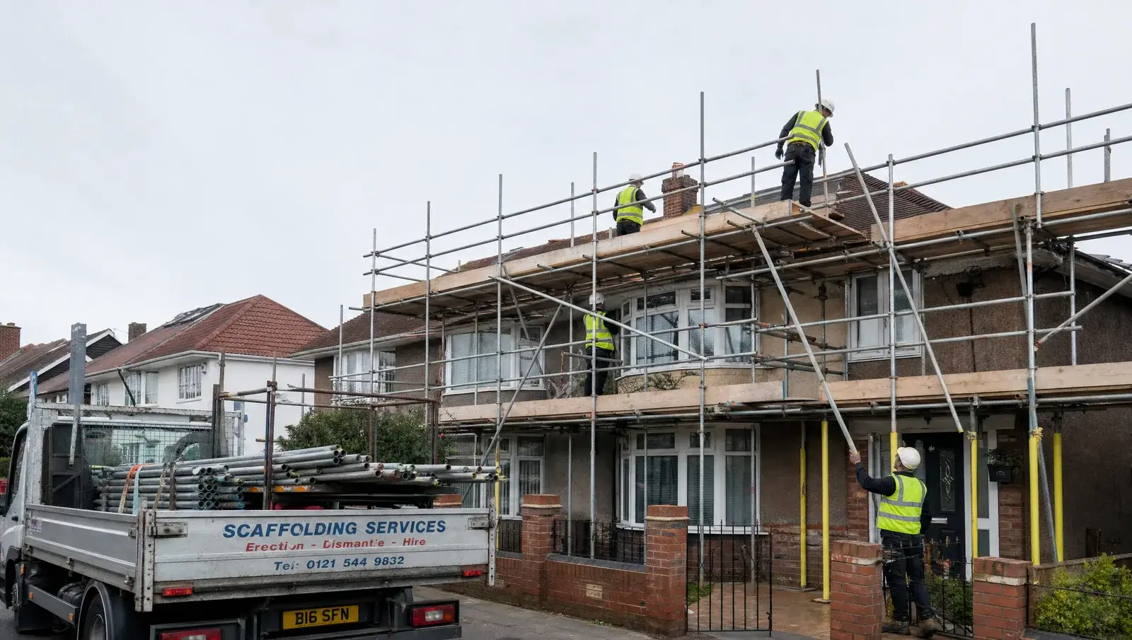Scaffolding being erected around a UK semi-detached house