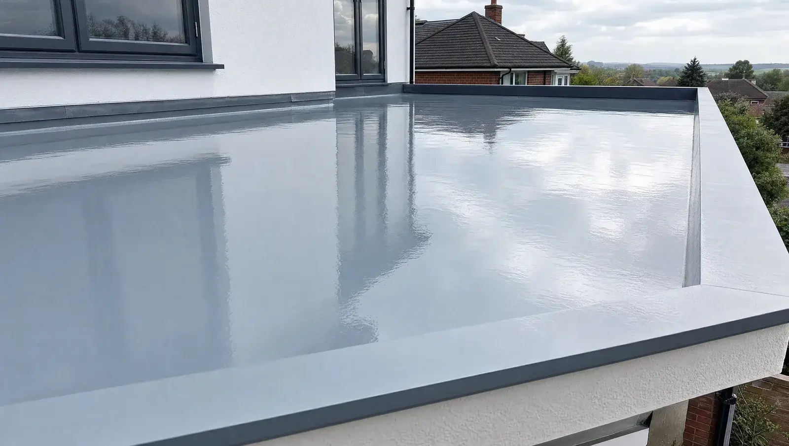 Glossy newly-cured grey GRP fibreglass flat roof with neat edge trims