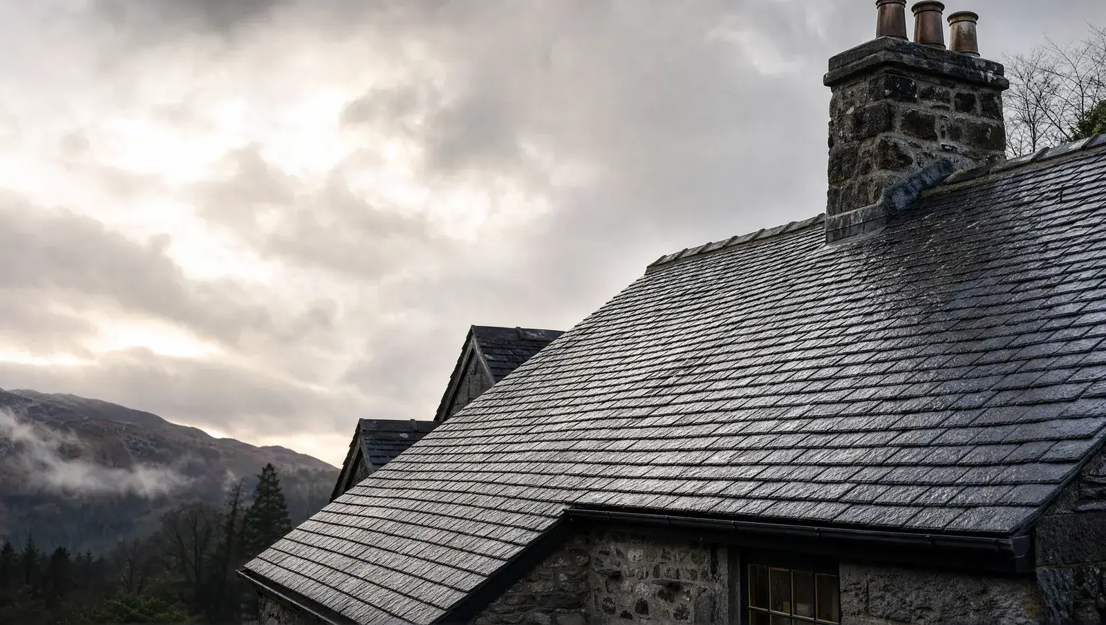 Natural slate roof on a period UK property with a rain-washed sheen under moody light