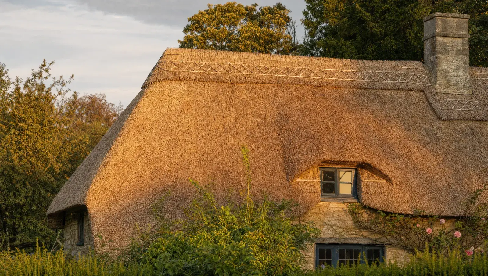 Thatched cottage roof in an English village with craftsman ridge detail