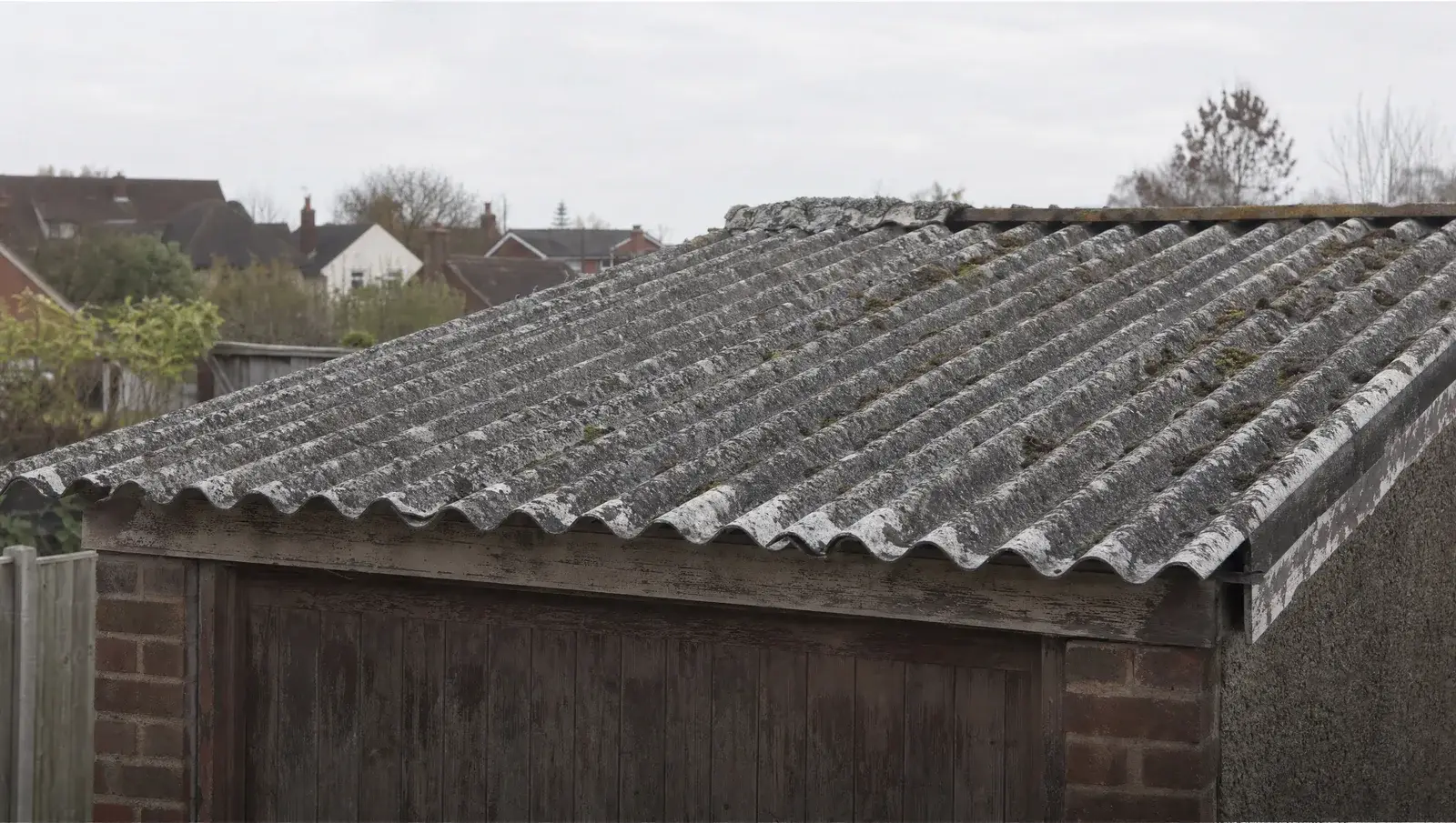 Old corrugated grey asbestos cement roof on a weathered UK garage