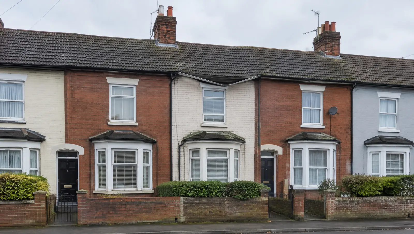 Row of British terraced houses with a continuous roof line and shared guttering
