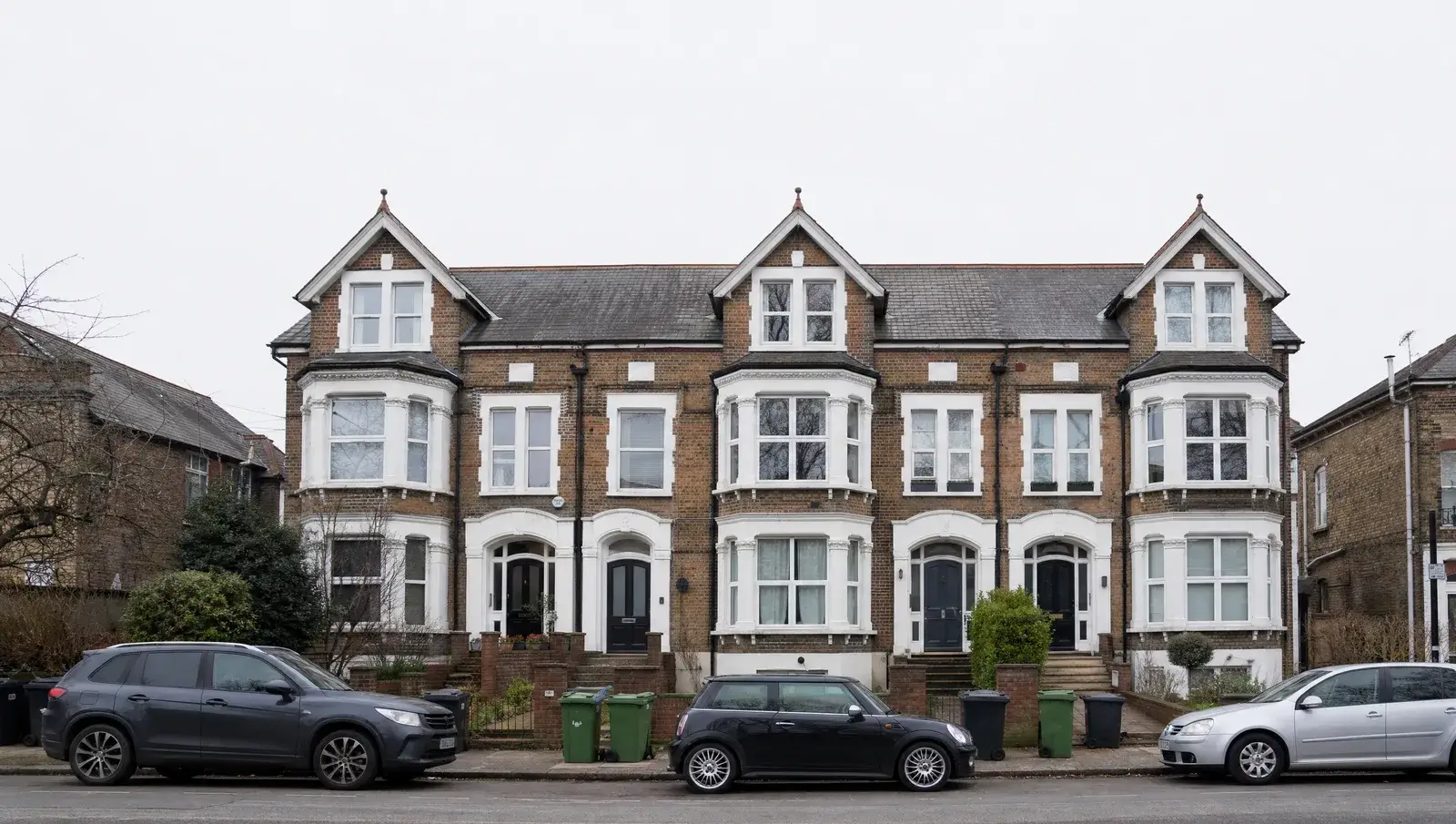 Converted Victorian building split into leasehold flats on a UK street with the shared roof visible