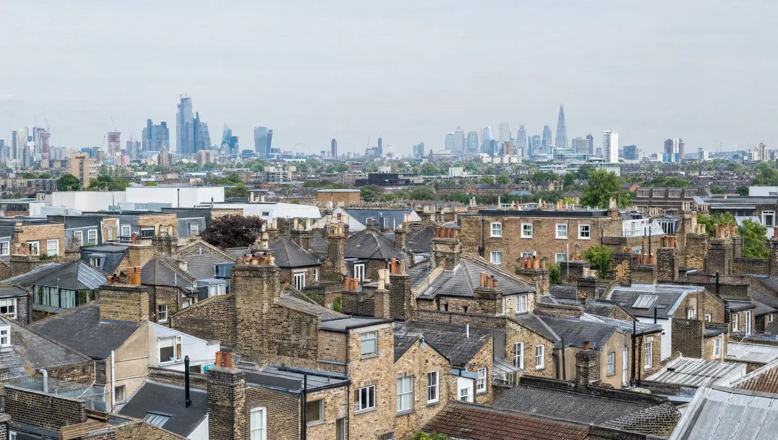 Sea of London Victorian terraced rooftops with the city skyline in the distance