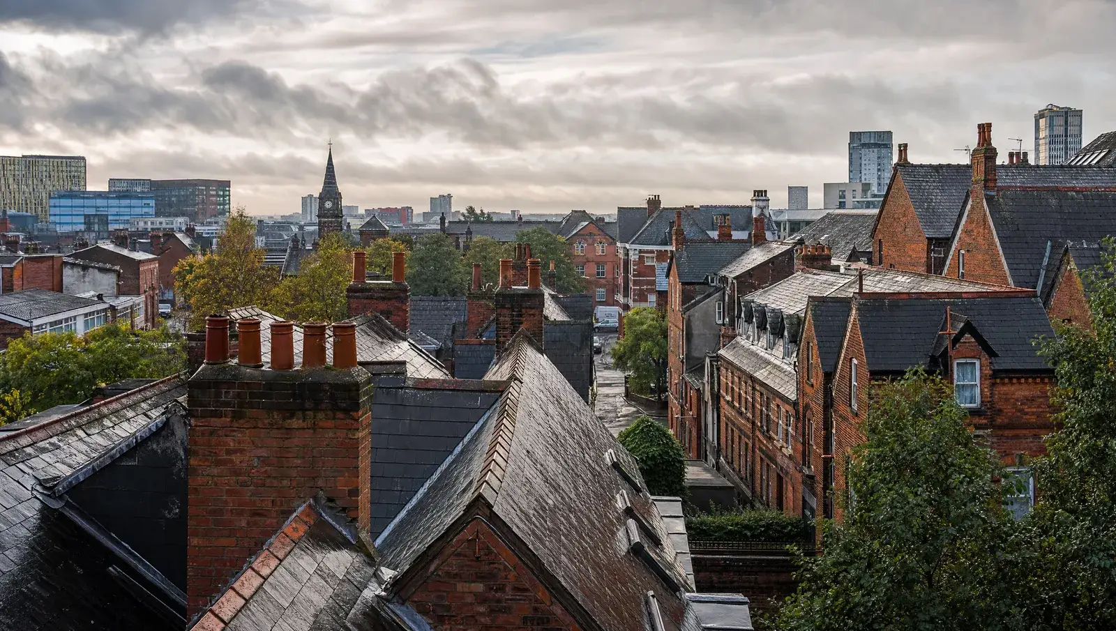 Manchester red-brick terraced rooftops with wet slate roofs in rain-washed light