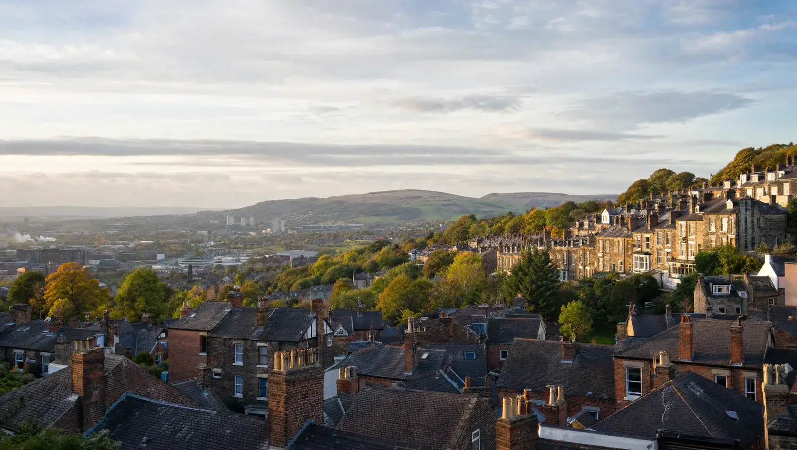 Sheffield hillside rooftops with the Peak District hills on the horizon