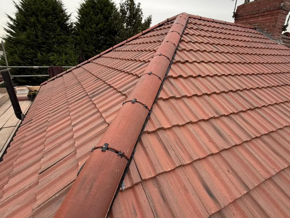 Finished red interlocking tile hip roof with new hip tiles