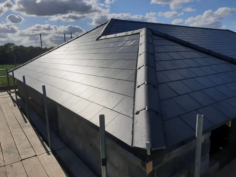 New grey hipped roof on a new-build extension with scaffold still up