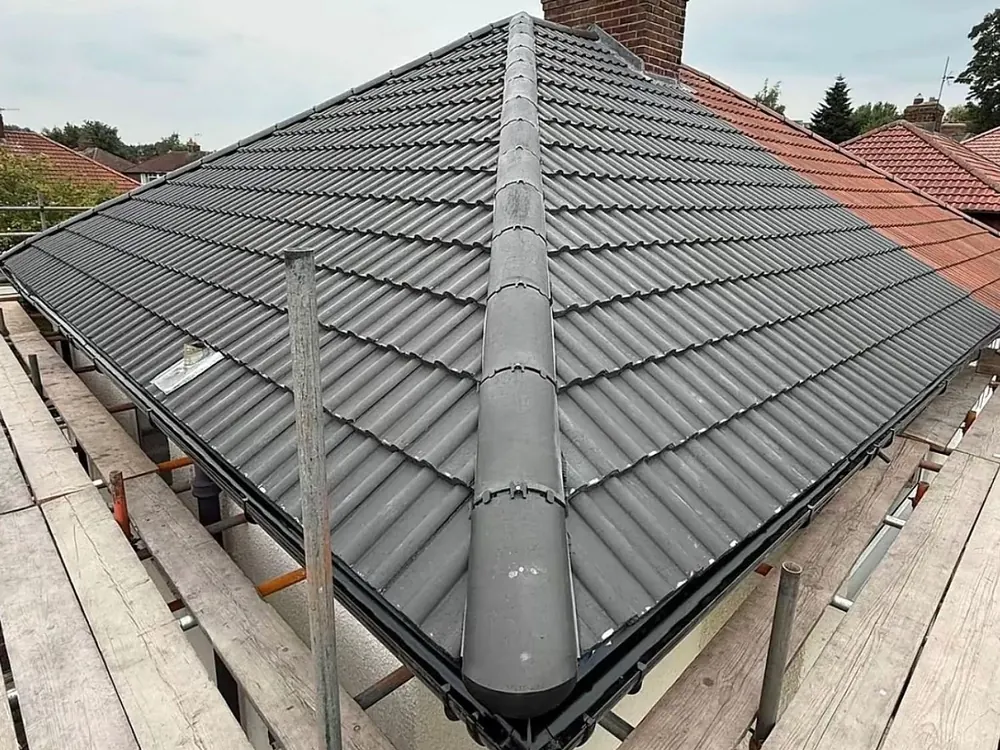 Hipped roof finished with a dry ridge beside the chimney