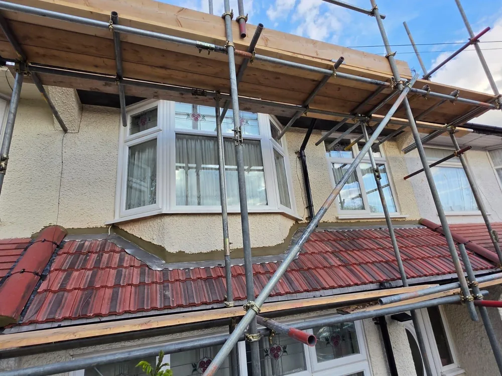 Front bay roof re-tiled in red tiles on a 1930s semi with scaffold up