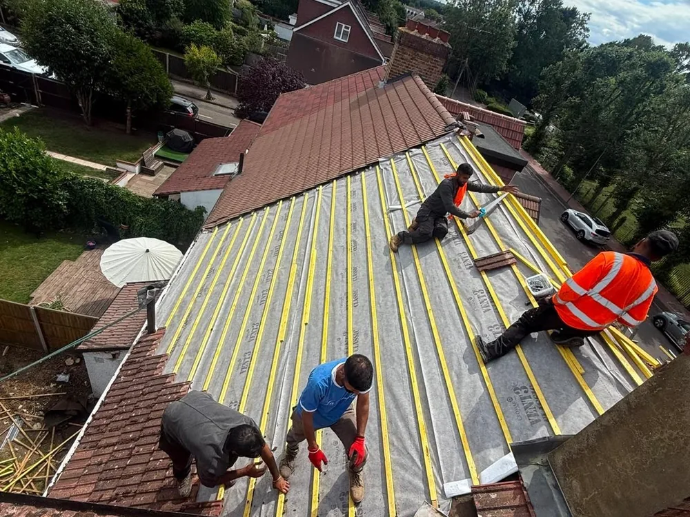 Roofing team laying battens over new membrane on a large semi