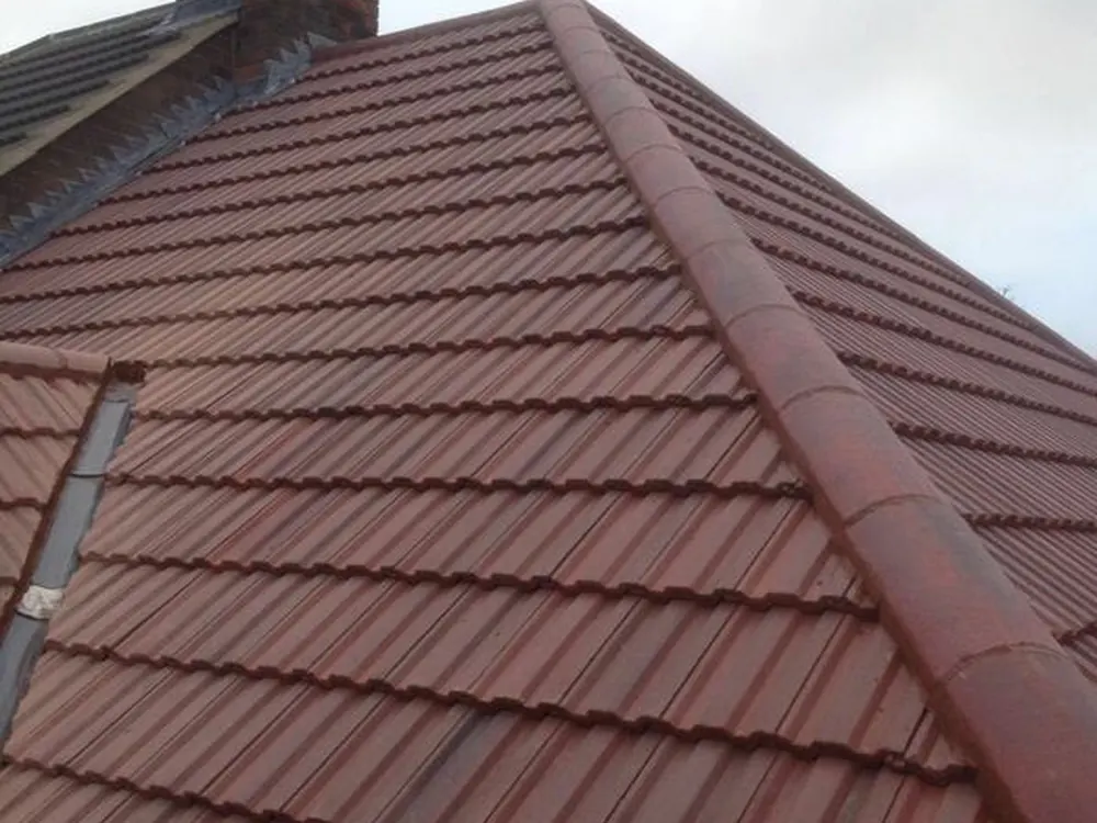 Red interlocking tile hip roof with a brick chimney