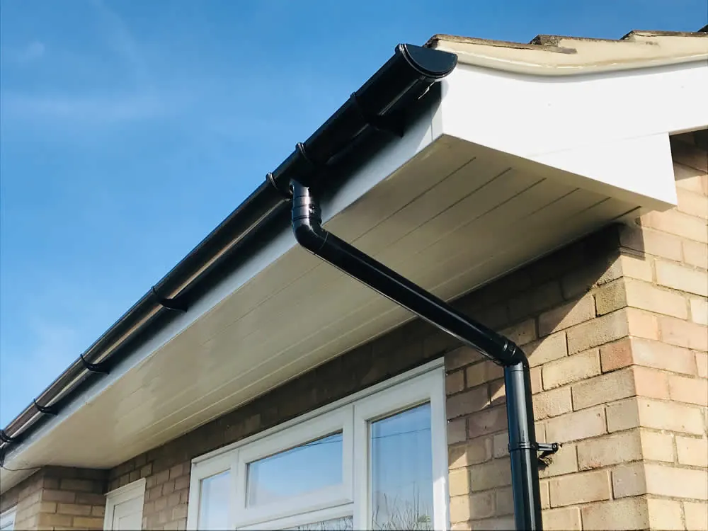 New white fascia and soffit with a black gutter and downpipe
