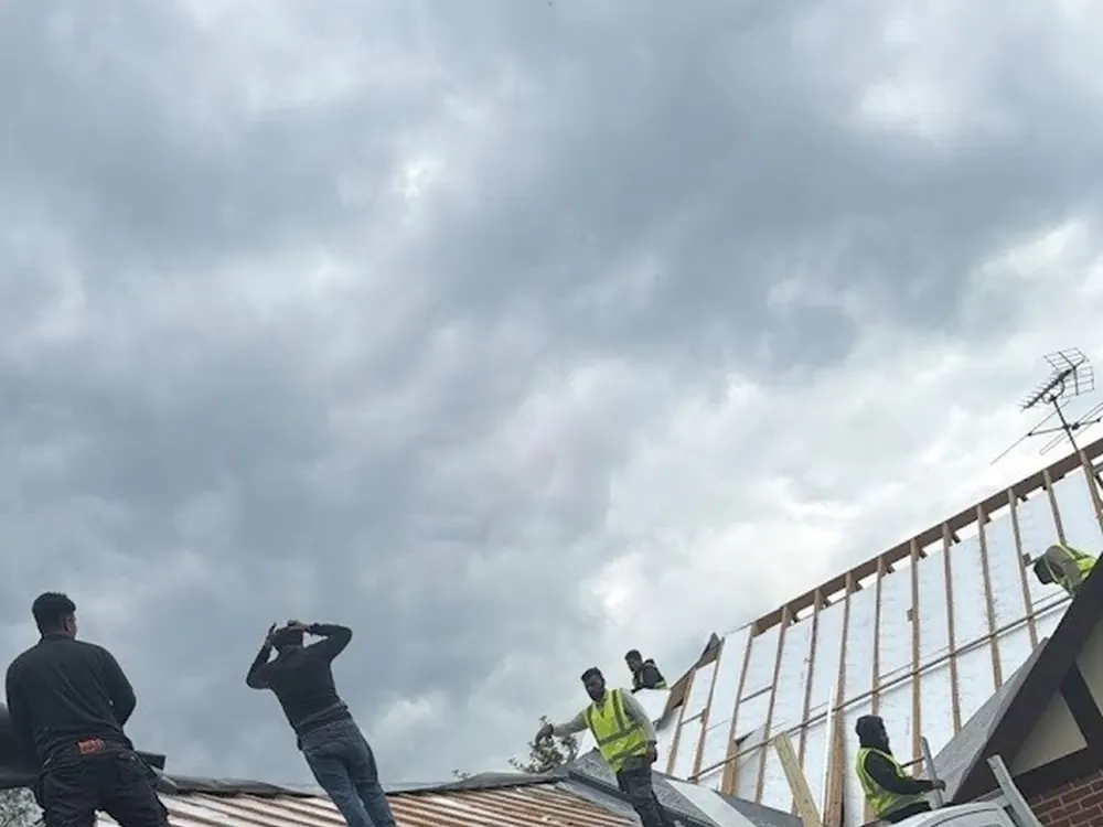 Roofers stripping the old covering from a garage roof