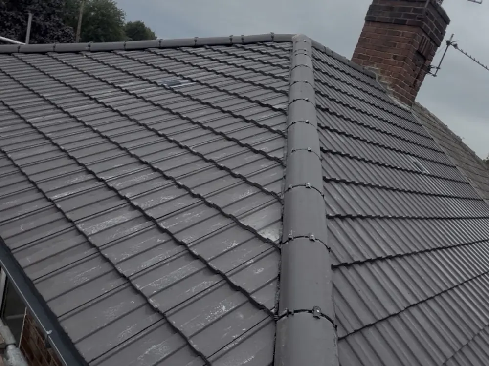 Finished grey tiled roof with a dry ridge