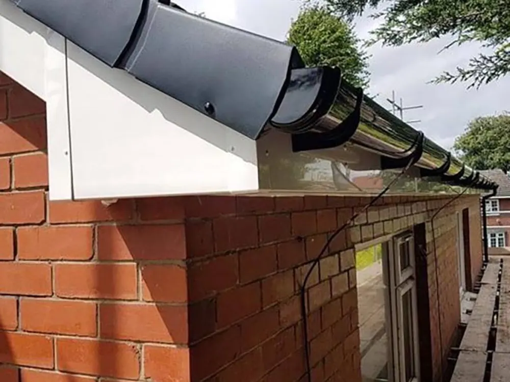 New black gutter and dry verge on a brick gable