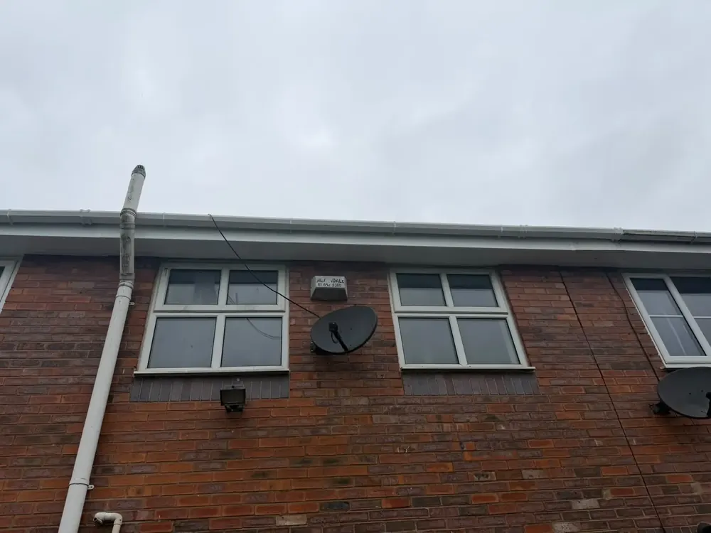 Long run of new white fascia and gutter on a brick building