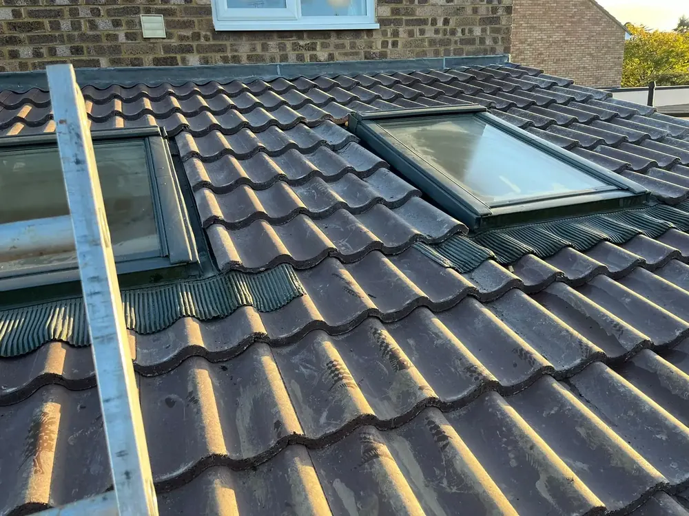 New interlocking tiles fitted around two roof windows on a rear slope