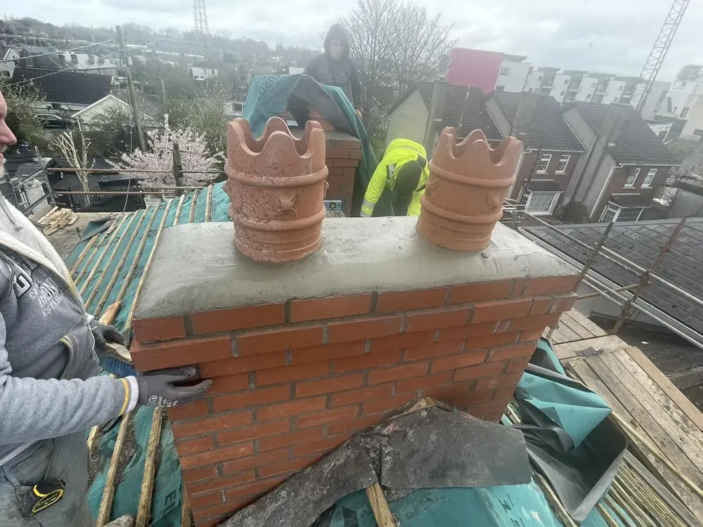 Brick chimney stack rebuilt with two new terracotta pots