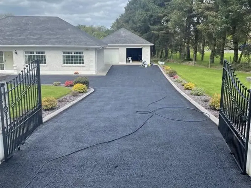 Driveway cleaned and sealed, seen through the open gates