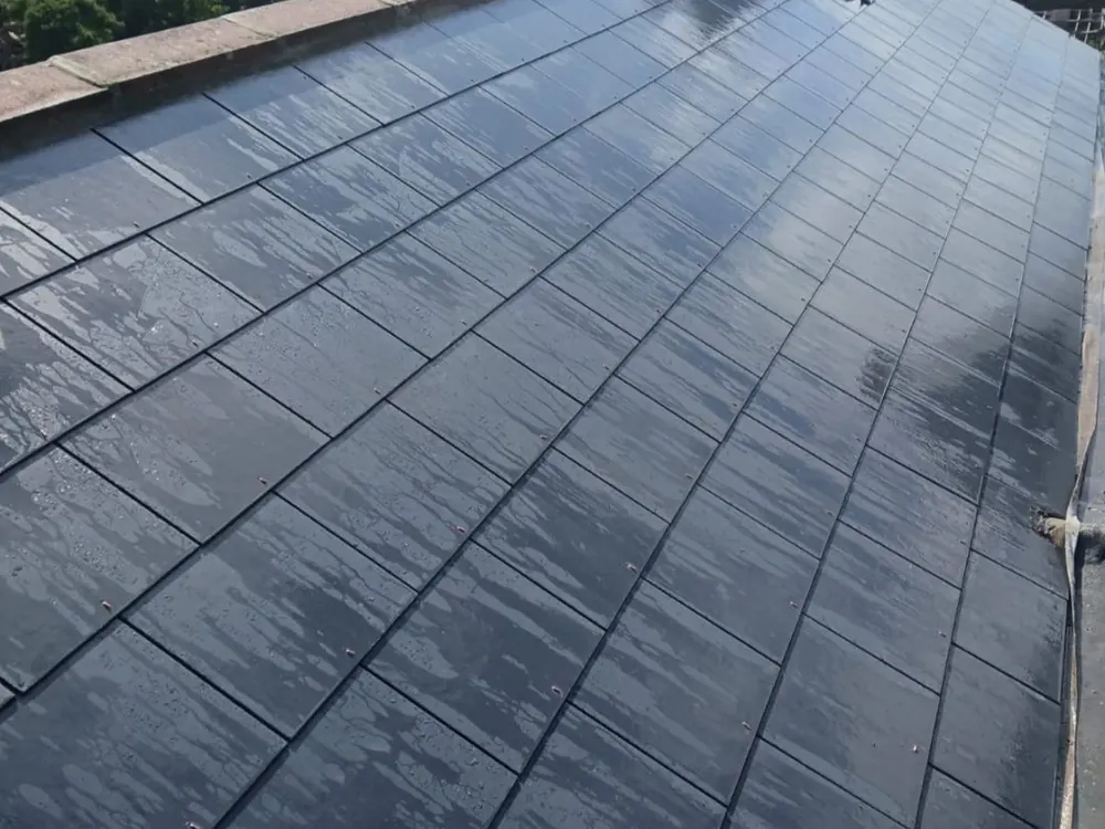 Finished new slate roof after rain with the chimney at the far end