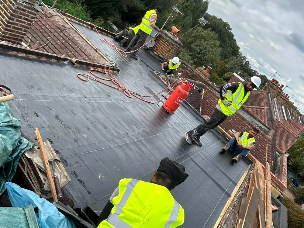 Imperial Roofcraft team in hi-vis laying a flat roof covering