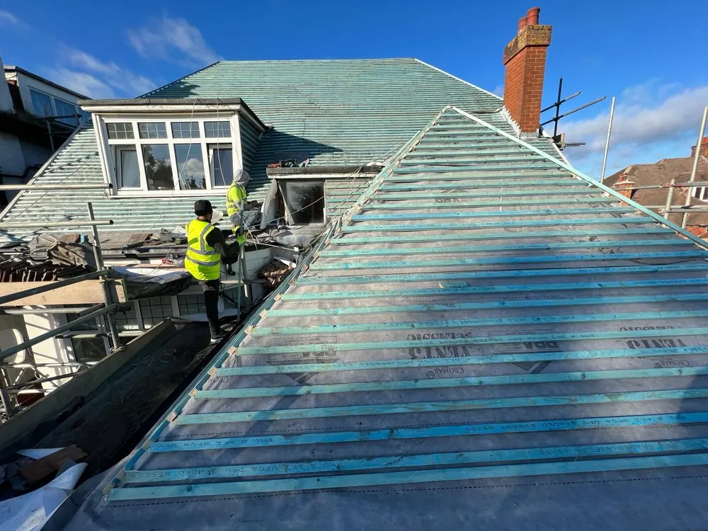 Roofer in hi-vis fixing new battens over breathable membrane