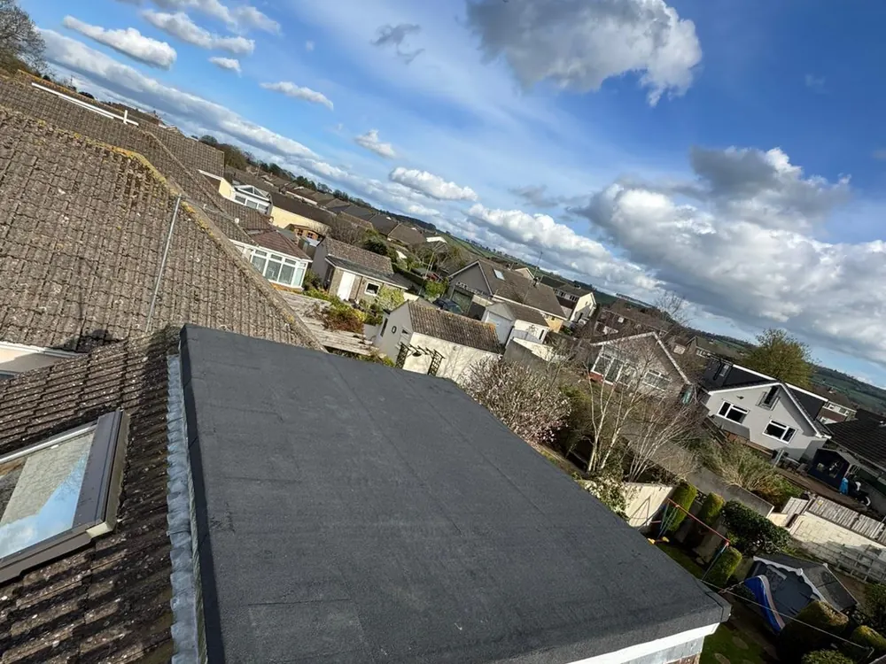 Dark flat dormer roof seen from the adjoining tiled slope