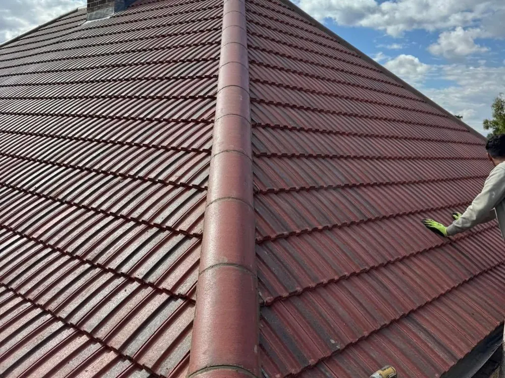 Finished red-brown tiled hip roof with ridge and chimney