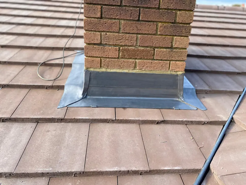 Chimney stack with new lead flashing dressed onto plain tiles
