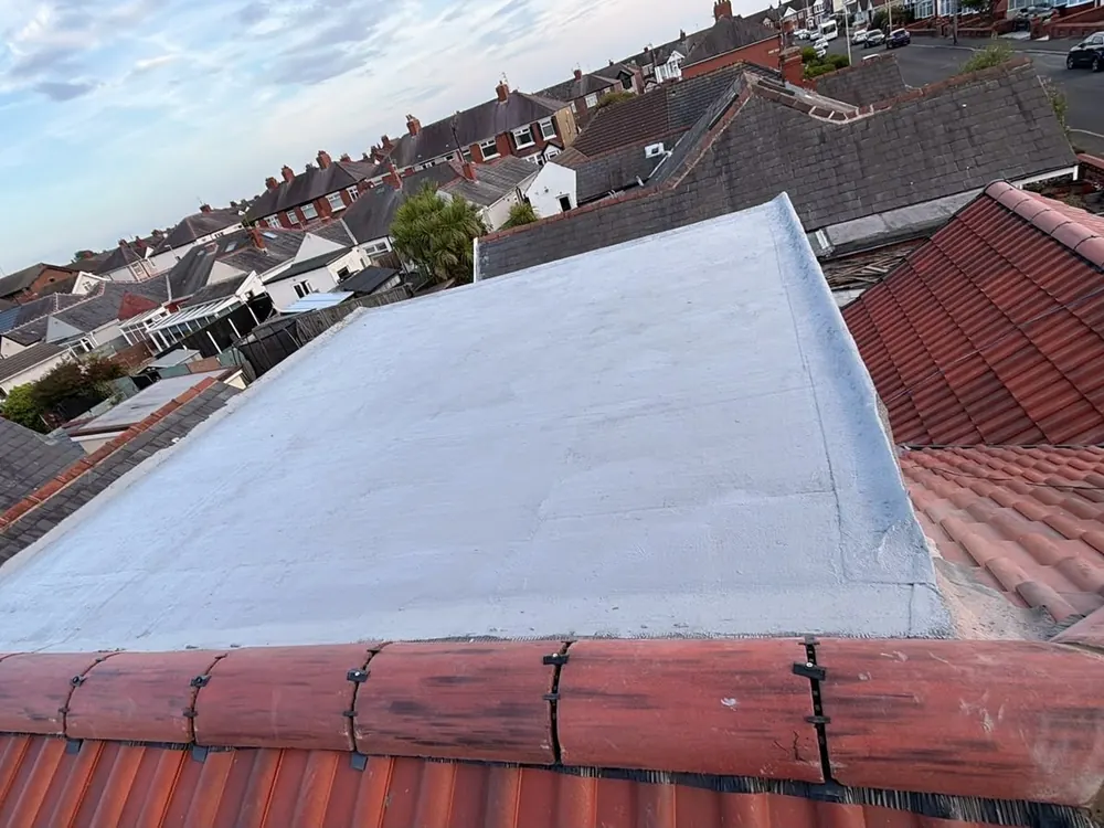 New grey flat roof between red tile roofs