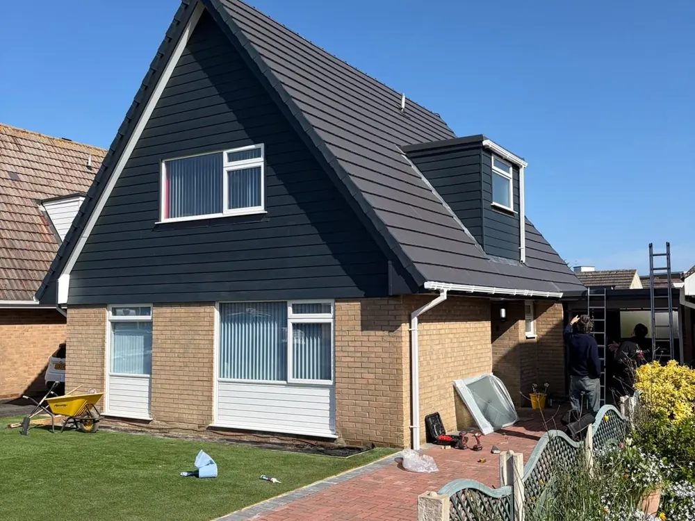 Chalet bungalow finished with new grey tiles and dark cladding