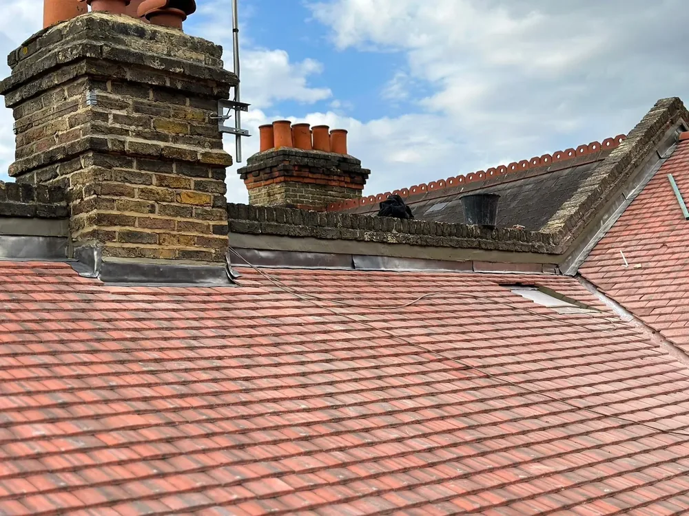 Brick chimney stacks with lead flashing on a red tiled roof