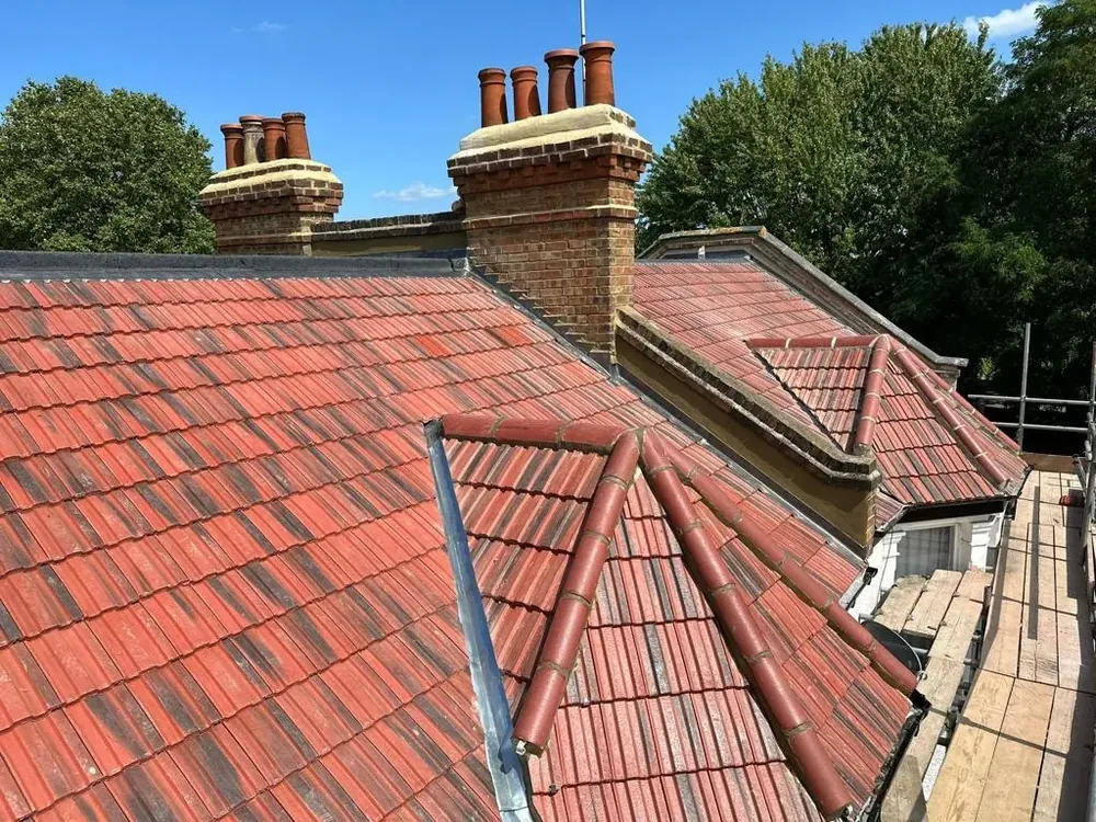 Red tile re-roof with new valleys between brick chimney stacks