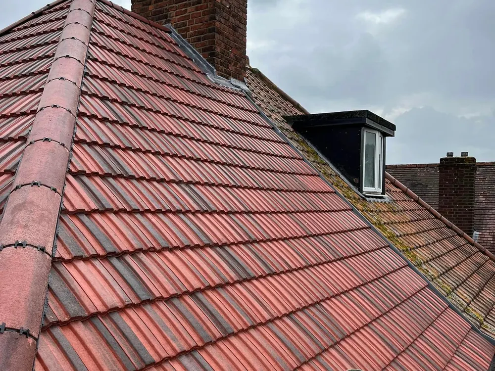 Red concrete tiled roof with a brick chimney and new ridge