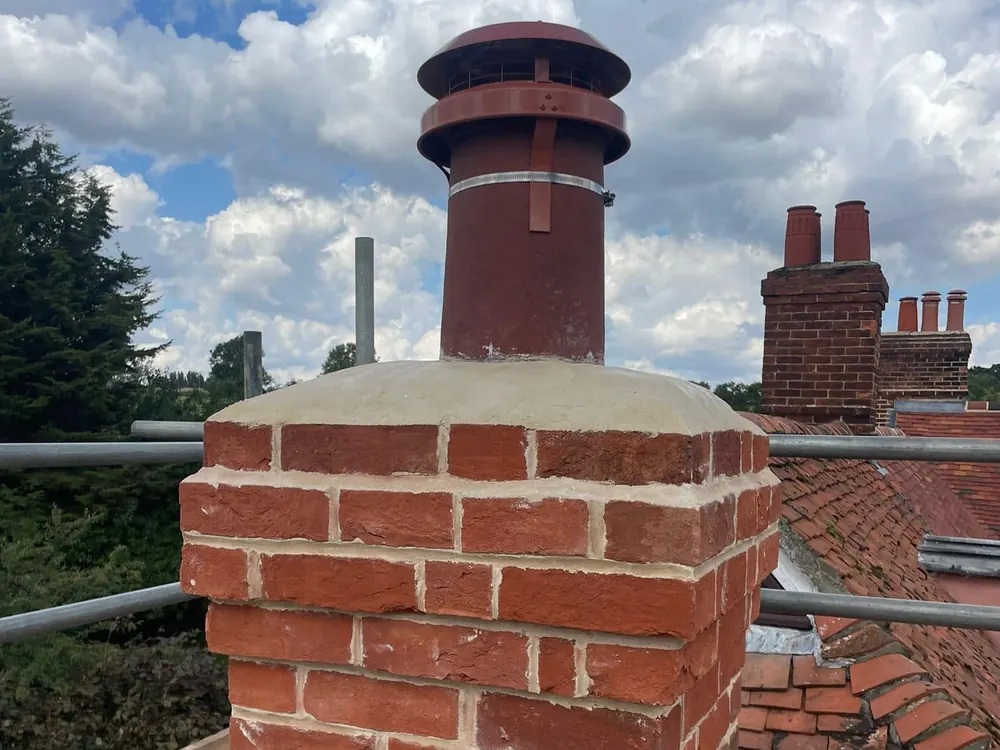 Rebuilt brick chimney stack with a new pot, seen from the scaffold