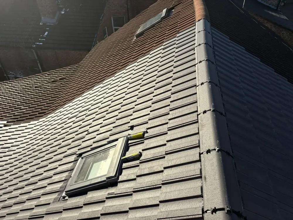 Tiled roof with a new roof window fitted and a dry verge
